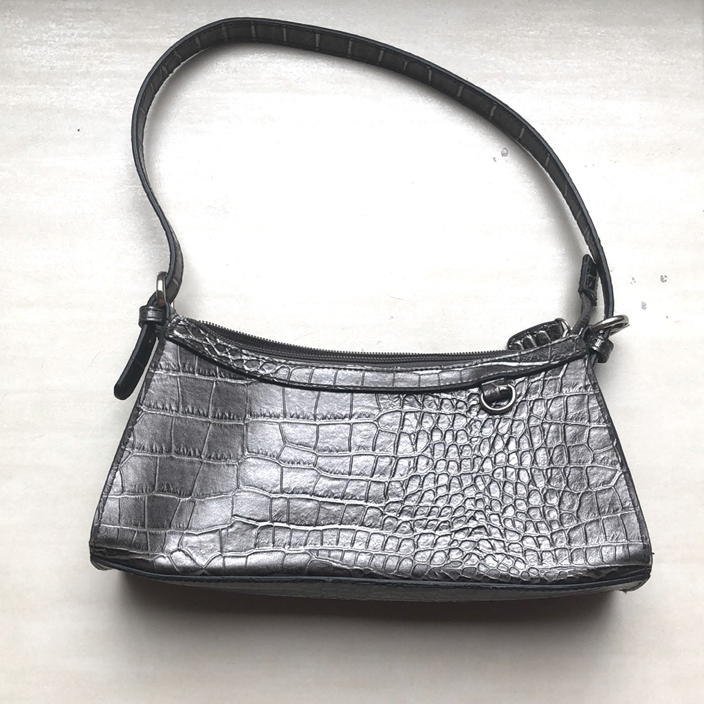 Grey crocodile-embossed baguette bag with a short shoulder strap, shown flat on a white background